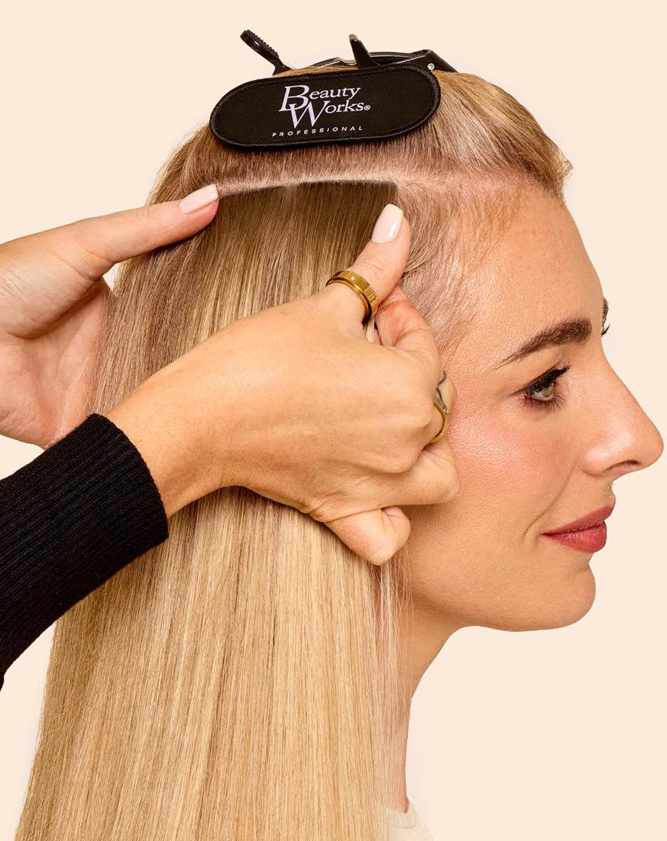 Blonde woman getting weft extensions. 