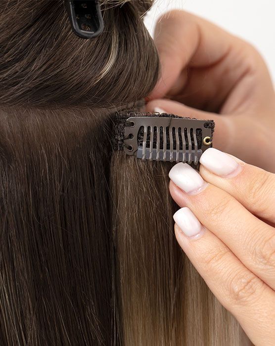 woman applying clip-in extensions 
